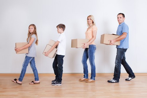 Household relocation support with movers carrying furniture in Aldgate